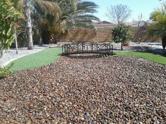 River rock design with artificial turf