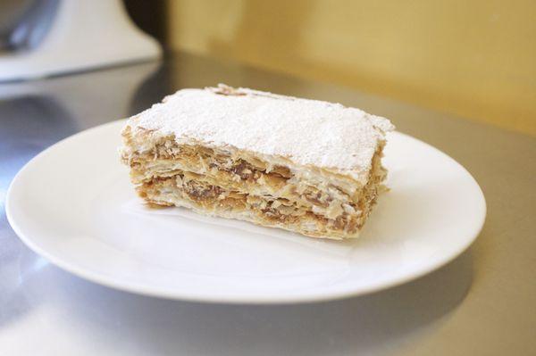 Tasty layered cake with dulce de leche (caramel) filling and a coat of powder sugar. (Contains: Milk, Wheat)