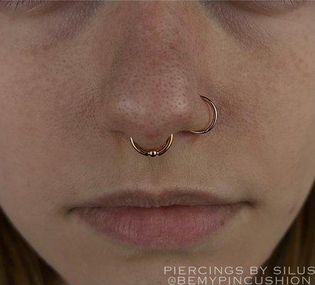 Delicate combination of rings in this clients septum and nose.  By Silus