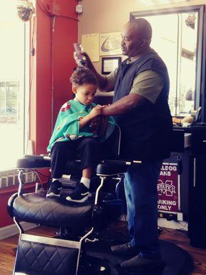 Tony helping to keep my son distracted while cutting his hair