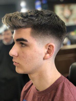 Mid low skin fade with a style cut on top.