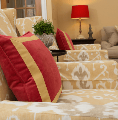 adding red pillows to a yellow ikat sofa fabric is really eyecatching.