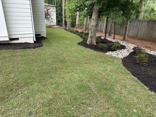 Fresh zoysia sod, mulch, and river rock