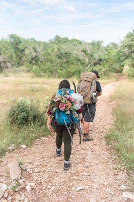 Adventurous couple hiking to elopement destination- Colorado Bend State Park