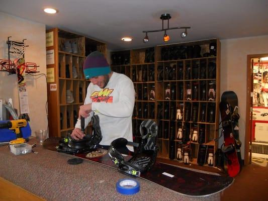 Kevin G. adjusting a snowboard binding