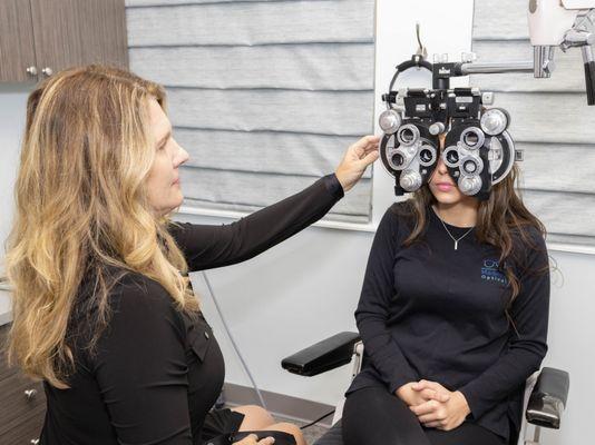 Dr. Pence in an exam room using a phoropter