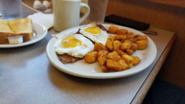 Eggs sunnyside with corned beef hash and crispy home fries, toast and a cup of bottomless coffee