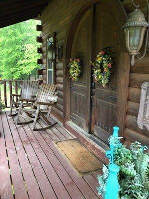 Large doors made of driftwood  and oversize rockers give an impressive welcome