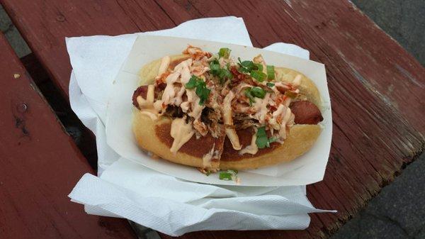 Godzilla Dog; bacon wrapped Kogel hotdog, topped with signature sweet pulled pork, kimchi, siracha aioli