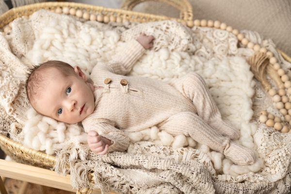 Handsome baby boy at Nicole Jackson Photography. Wearing a studio outfit in our boho moses basket