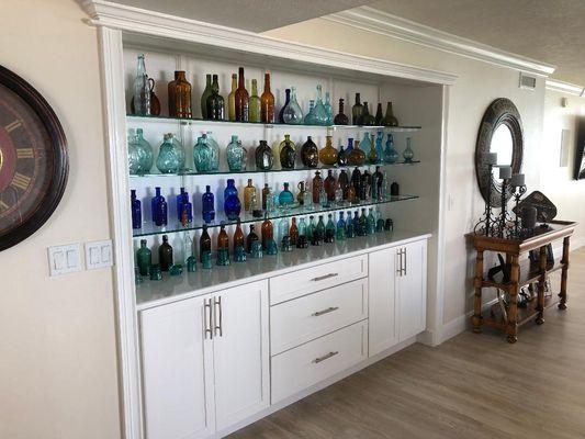 Built in storage unit featuring white cabinetry designed by Apollo Kitchen & Bath.