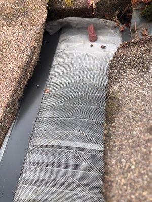 Gutter filter installed over gutter next to tile roof