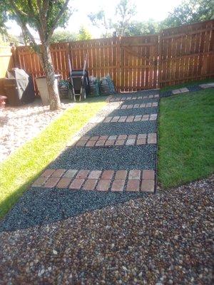 Walkway with pavers and black shadow basalt 5/8 also 1 in Texas Stone for drainage, metal edging and weed barrier.