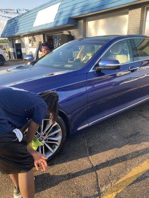 Teen employee applying tire shine