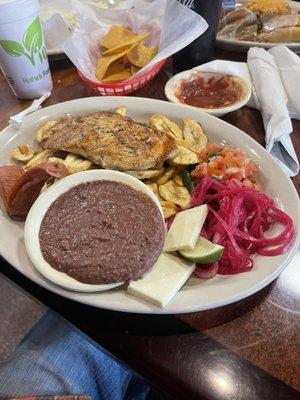 Pollo a la plancha a lot of food for 12.99 Grill chicken Served with fry green plantain, beans, cheese, pico de gallo, pickled onions.