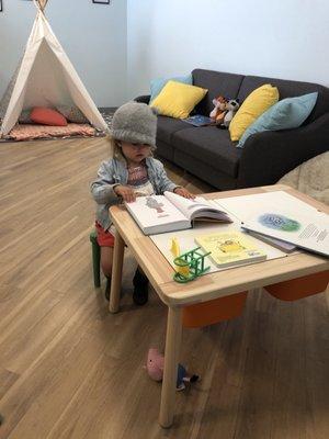 Darling waiting room with lots of books, toys, a teepee and other exciting things for kids.