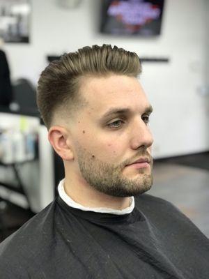 Low bold fade, with scissor work and blow dry and top. With a # 1 beard trim