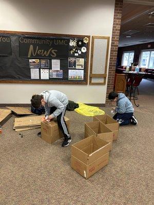 Gabe and Eli hardened work making boxes for our mobile food pantry.