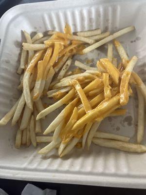 Uncooked Fries with slices of cheese cheese melted on them