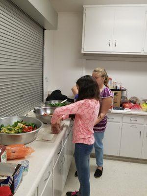 Volunteer Children cooking for Safe Space. People need to reach out and hear the stories before making everyone scared. It is a positive