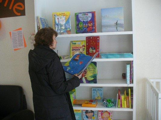 A grandmother checking out one of the many nursery rhymes books.