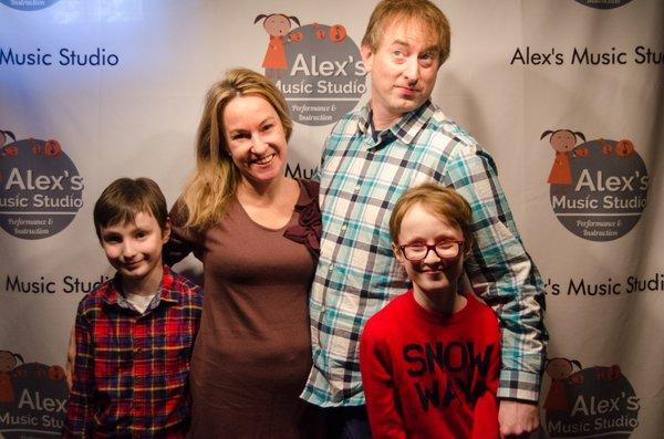 One of our families posing in front of our photo wall at our Winter Recital at Beat Kitchen