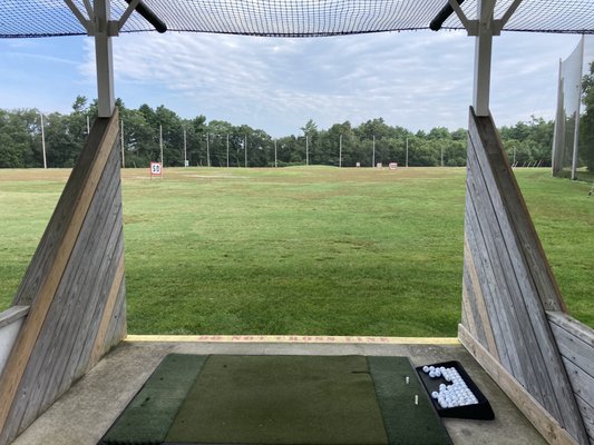 Two levels of driving range stalls. They have mats as well as grass.