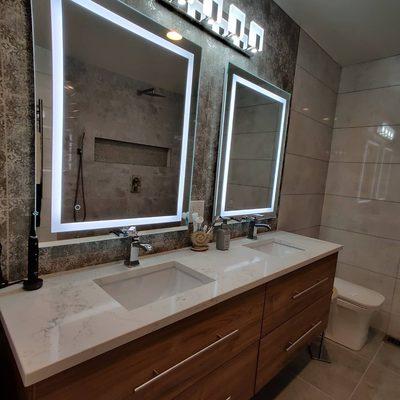 Suspended vanity with Kohler fixtures and LED mirrors