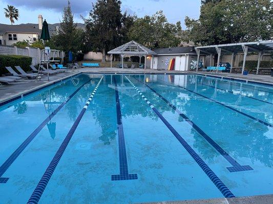 Huge pool with lots of tables and lounge chairs.