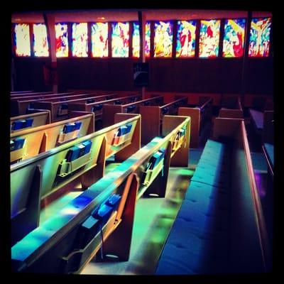 Our beautiful sanctuary bathed in the light of our stained glass windows depicting the Stations of the Cross