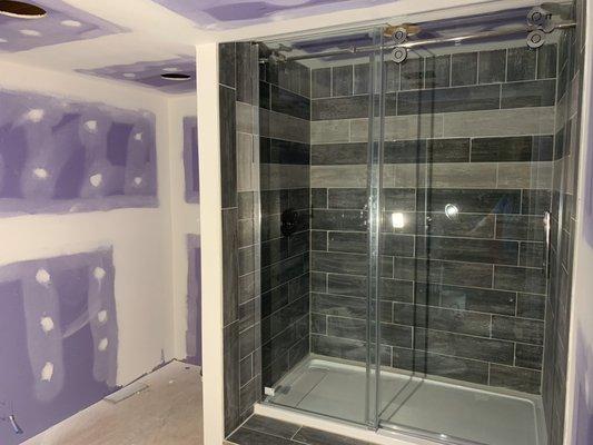 Shower install with tiled surround and glass shower door