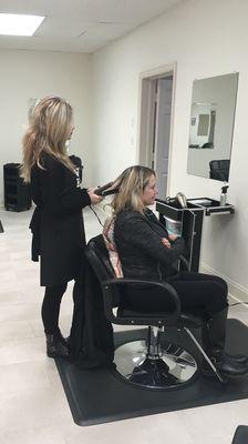 A prominent student straightening out her clients hair at Allgood Beauty Institute, LLC