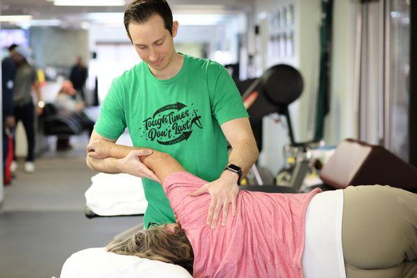 Dr. Mikeal Gibbens treating his patients' shoulder injury.