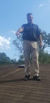 Inspecting roofing pointing out defects