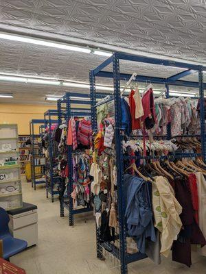 Back of the store; clothing racks.