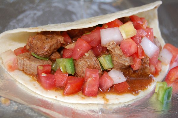 Carne Guisada Chunks of lean beef simmered in tomato sauce, onion, garlic, cumino, paprika, salt and pepper to make a rich gravy (guisada).