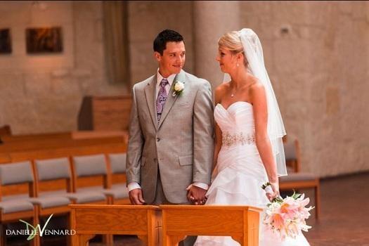 Bride and Groom looking into each others eyes and holding hands during catholic ceremony