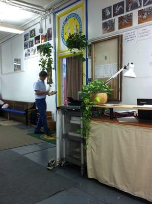 Mestre Ombrinho testing a pandeiro at the threshold of the studio