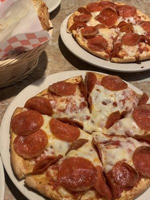 2 personal pepperoni pizzas with and order of cheese bread on the side.