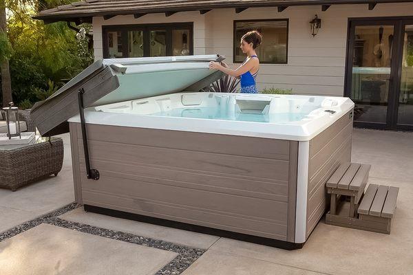 Woman opening the cover of her Hot Spring hot tub