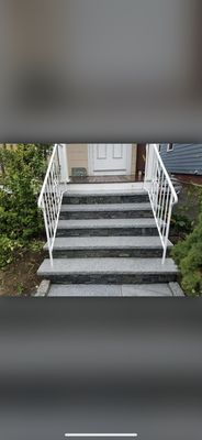 Natural salt and pepper granite treads with a natural stone veneer facing