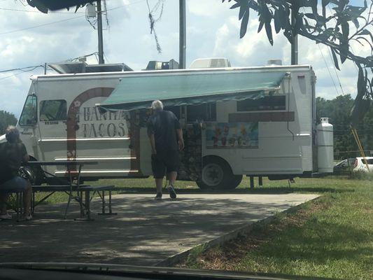 The whole truck and people waiting for their yummy food.