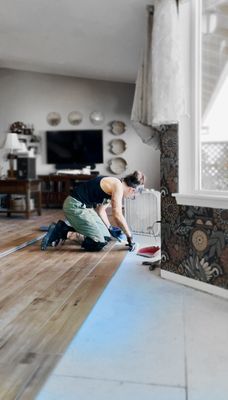 Olive installing floors in a home on Camano Island.