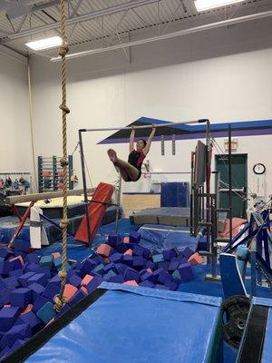 Swinging on the high bar during a lesson.