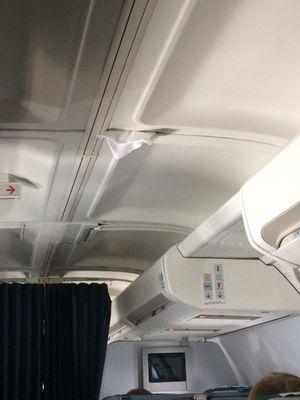 Pillowcase stuffed into the ceiling of the plane.