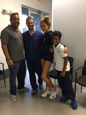 High School Volley Ball Athlete visiting her Chiropractor with Dad and little brother.