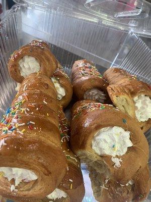 Bread roll stuffed with icing, with honey and sprinkles on top.