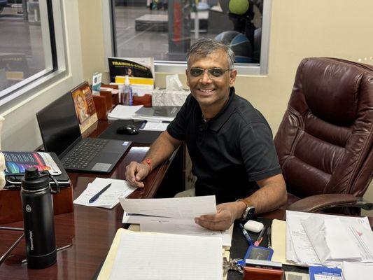 Gopal Patel in his office looking over patient documents.