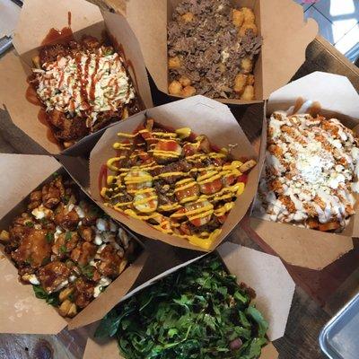 Clockwise from the top -- cheese steak tots, buffalo chicken, salty pig, general tsos, q-tine, cheeseburger fries in the middle