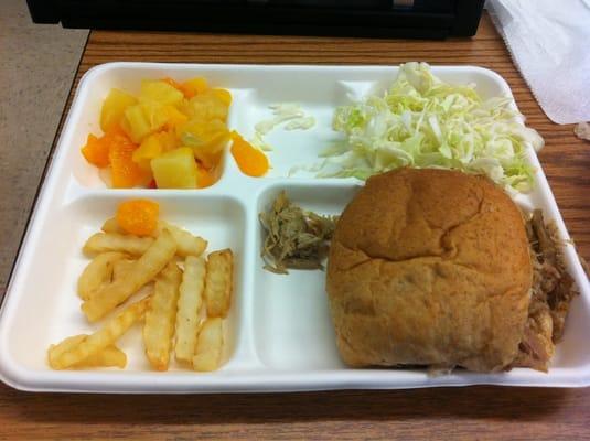 Kalua Pork on Whole Wheat Bun, Salad, Fruit Cocktail and Fries.